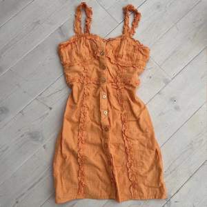 Säljer denna super vackra klänning från Urban Outfitters usa😍 älskar den, men den är tyvärr för liten och blev bara använd en gång:(. Den fina Färgen visas bäst på sista bilden 🍊 knapparna går att öppna/stänga 