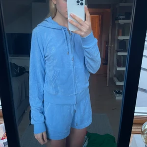 Juicy Couture Set - Babyblått Juicy Couture Set. Det består av två delar, shorts och ”zip-hoodie”. Shortsen är helt oanvända och har prislapp kvar medan tröjan enbart är använd en gång. De är i ”frotté”. Köpta på Nelly.com för 1099 respektive 599. Shorts i strl S och tröja M
