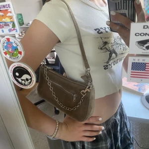Axelväska  - Säljer nu min axelväska från Brandy Melville i riktig mocka!😍 Har lagt till kedjan själv, men den går att ta bort! Som ny förutom att dragkedjan inuti har gått sönder, men som säkert går att fixa! (Säljer även toppen på första bilden)💖💗