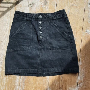 Svart Jeanskjol - Hollister  - En svart jeanskjol från hollister med coola framfickor! Säljer pga den är för lite för mig! 