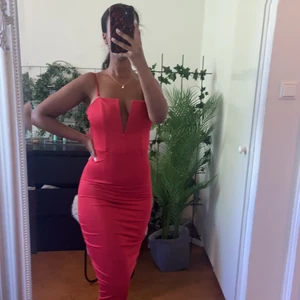 Röd figurnära klänning med korsettimitation - Röd knälång klänning med korsettimitation till överdel. Justerbara band och stretchigt material. Passar till dejtkväll eller något annat uppstyrt! 