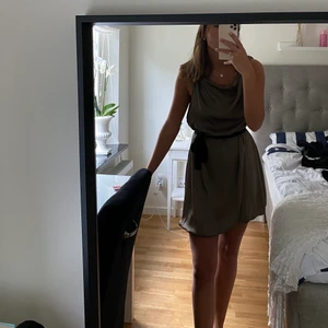 Klänning med skärp i midjan - Söt klänning med skärp i midjan, storlek 36. Köpt på MQ från märket ”Stockholm”. Färgen skulle jag säga går mot olivgrönt.