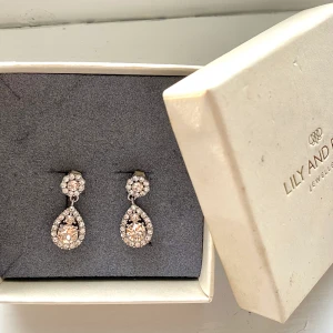 Lily and rose örhängen -  Lily and rose örhängen, använda en gång. Fina till vardags men även till lite finare ställen! Dessa är silver och rosé. Ask medföljer :)