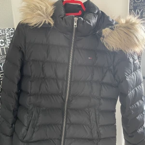 Tommy jeans vinterjacka - Säljer min gamla vinterjacka i storlek M, köpt på zalando för 2500 kr.   Använd 1 säsong och har varit i garderoben sedan dess pga köp utav en ny.   Jackan är som ny. Pälsen är fake och avtagbar, luvan med.
