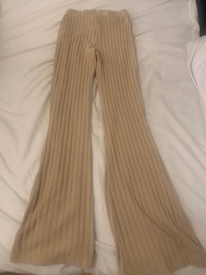 Ribbade beiga byxor  - Beiga ribbade byxor, storlek XS. Köpte från en annan här på plick men då de satt för tight och var för korta i benen då den andra skrivit fel storlek så säljer jag de. De är från bikbok jättefina jag har aldrig använt