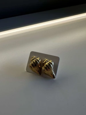 Örhängen  - Guldiga örhängen, formade som snäckor🐚Aldrig använda. Köparen står för frakt🫶🏽 Har massor av andra örhängen i min profil, så gå gärna in och kika💕