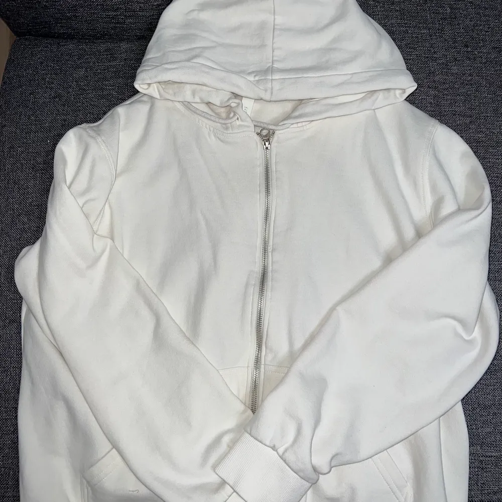 Helt ny oanvänd vit zip up hoodie i storlek L som passar M . Passar  även S om man vill ha den oversized! . Hoodies.