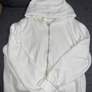 Helt ny oanvänd vit zip up hoodie i storlek L som passar M . Passar  även S om man vill ha den oversized! 