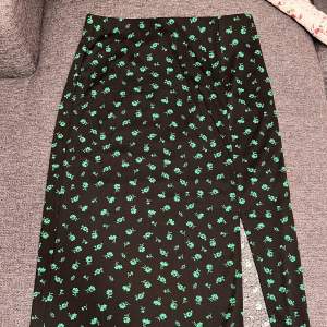 Grön och svart blommig maxi kjol med slits i storlek M.