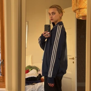 Adidas track jacket - Sjukt snygg adidas jacka. Marinblå med vita ränder och dragkedjor. Polokrage. Säljer då jag hade velat att den satt tajtare. Unisex, Storlek S. Köparen står för frakt, betalning sker via Swish! 