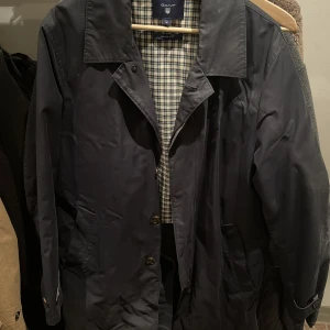 Gant trenchcoat blå storlek M - Blå trenchcoat från Gant, funkar även som regnrock, storlek M, sitter mer som en L, använd en del med gott skick 