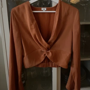 Orange blus  - Superfin orange blus/crop top i satintyg från River Island strl 36-38 (är som en 36)  Använd 1 gång på en tillställning  Köpare står för frakt   