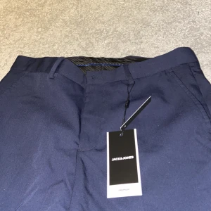 Kostymbyxor Herr  - Ett par jätte snygga mörkblåa kostymbyxor för herr, oanvända och säljs pga att de inte passade. Från JACK&JONES och har skön passform. Funkar säker för kvinnor också :)  Säljes för 200kr + frankt. Pris kan diskuteras :) 