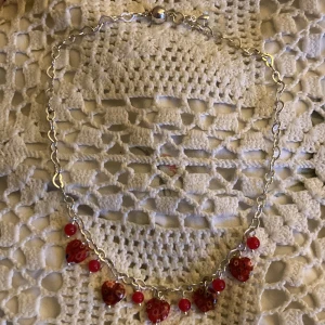 Rött halsband med hjärtan  - vackert halsband jag har köpt från sellpy! det är små hjärtan med silver detaljer. Det är även magnetlås. 