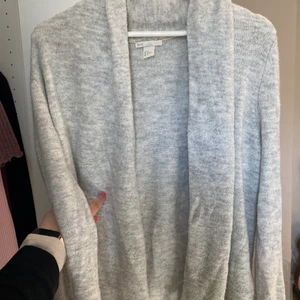 Kofta - Varm grå lite tjockare kofta med lite mer tyg vid kaldén och nacken. Perfekt för sommarkvällar alternativt kyligare dagar. 