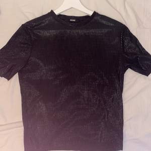 En svart skimrig tröja i ett skönt tunt material 