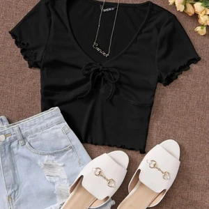 Svart tröja från SHEIN  - Svart ribbad tröja från SHEIN med rosett i mitten. Aldrig använd.                                                                                                             Fraktpris kan ändras!