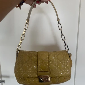 Dior väska - Dior väska i patent leather. Jätte bra skick utom lite färgning av kedjan som visas på bild och även den gula färgen är lite olika på väskan av solen. Inget man egentligen ser. Kontakta mig för fler bilder 😊jag har kvitto också!