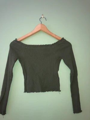 Grön topp - Grön ribbad topp som är lite offshoulder, i bra skick!