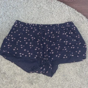 Shorts - Mörkblå shorts med rosa blommor på från hm i strl 170