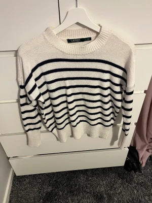 Stickad tröja - Säljer denna vit/mörkblå stickade tröja från Ralph Lauren! Några år gammal men väldigt fint skick!