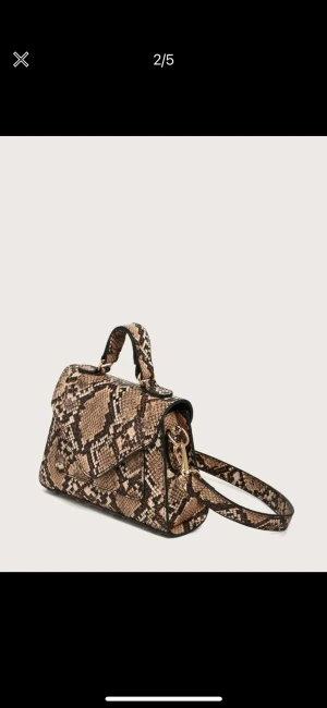 Axelremsväska med ormskinnstryck - Liten väska med avtagbar och justerbar axelband. Denna väska är helt oanvänd.