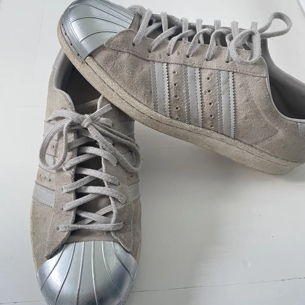 Säljer ett par adidas skor i grå färg. Väldigt fint skick och har en metall bit längst fram på skorn! . Skor.