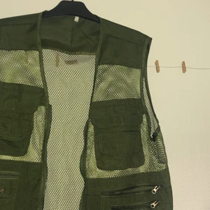 Väst med massa fickor - Fin tunn väst i nätmaterial med flera fickor. Ganska oversized och perfekt för lager på lager.  Militärgrön. 