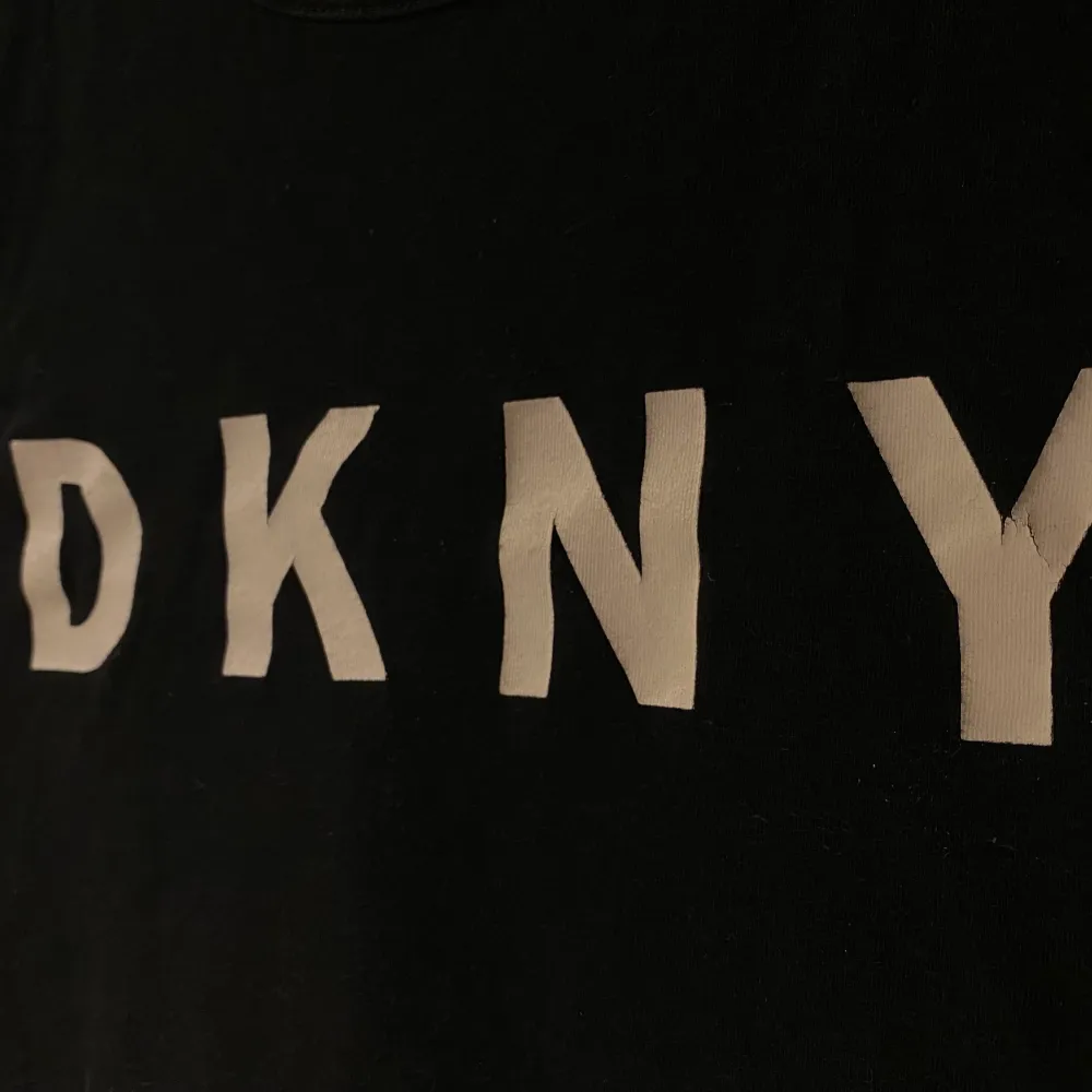 En svart t-shirt i storlek XXS (funkar även som XS) som köptes i en av DKNY’s butiker för några år sedan. Tröjan består av 100% bomull och är väldigt fin i kvaliten. Tecken på användning finns dock (se bild 2 & 3) då det finns lite sprickor i texten - därav priset. Skriv gärna för fler bilder <3. T-shirts.