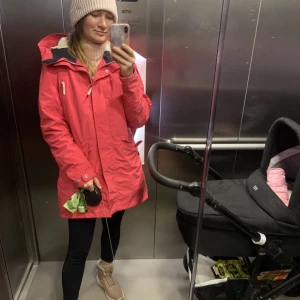 Didriksons rosa jacka 42 - En fin lång rosa jacka ifran Didriksons i fint skick.  Storlek 42. Vindtät och vattentät. Använd i ett par månader när jag var gravid.  Säljer för nu är den här jackan för stor för mig. Nypris ca 2000kr