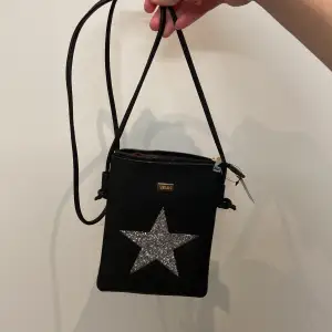 Cool handväska med en stjärna med glitter på, oanvänd och är i nyskick, köpt för 199, mått: höjd ca 20 cm, bredd ca 15 cm