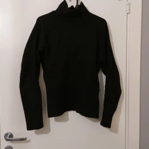 Bik bok - En vanlig svart tröja med hög nacke och slit på armarna