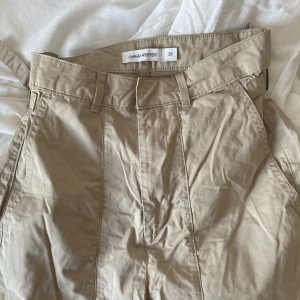 Beige wideleg chinos - Köpt second hand. Fråga gärna om bilder på hur den sitter på!