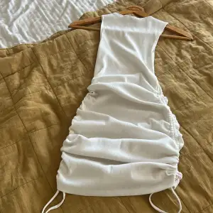 Säljer min vita klänning från hm som man kan korta och länga med hjälp av sidorna