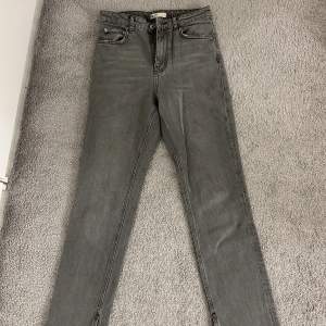 Gråa jeans med slit från Gina Tricot. Storlek 36, använda 1/2 gånger därav fint skick!