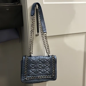 Skinnväska från Zara  - En favoritväska i blå metallic läder som används för sällan! Går att bära över ena axeln eller med längre kedja som crossbody bag.   Lite använd och i fint skick. Riktigt bra kvalitet!  Köpt på Zara  