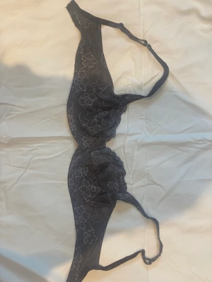 Bh - En mörkgrå bh med spets från Lindex . Jättefin med mönsterna. Önskar jag kunde ha den men den är tyvärr Förstor. Den är i storlek 75D och knappt använd utan några defekter 