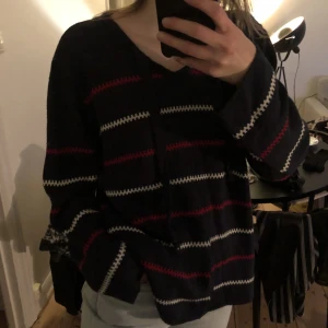 Stickad tröja - Mörkblå stickad tröja med vita och röda ränder. Bra skick. Storlek XL.