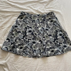 Gina Tricot Kjol stl. M - Klockad tunnare kjol med blomtryck från Gina Tricot. Dragkedja på sidan. Polyester