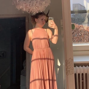 Rosa balklänning, storlek 36 - Gammaldags/smuts rosa långklänning från asos. Köpt 2018 och finns inte längre på hemsidan. Jag är 170 lång och den funkar för folk som är ännu längre eftersom den var för lång för mig, den går även att klippa kortare utan att tyget förstörs. Tycket är lite stretchigt och resåren i midjan går att töja en hel del. Bara skriv till mig ifall det är något du undrar över! (: