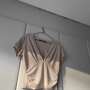 Blus från Bikbok i strl M - En beige fin blus i storlek M ifrån Bikbok. Väldigt mjukt och stretchiga material som även kanske skulle kunna passa S och L. 