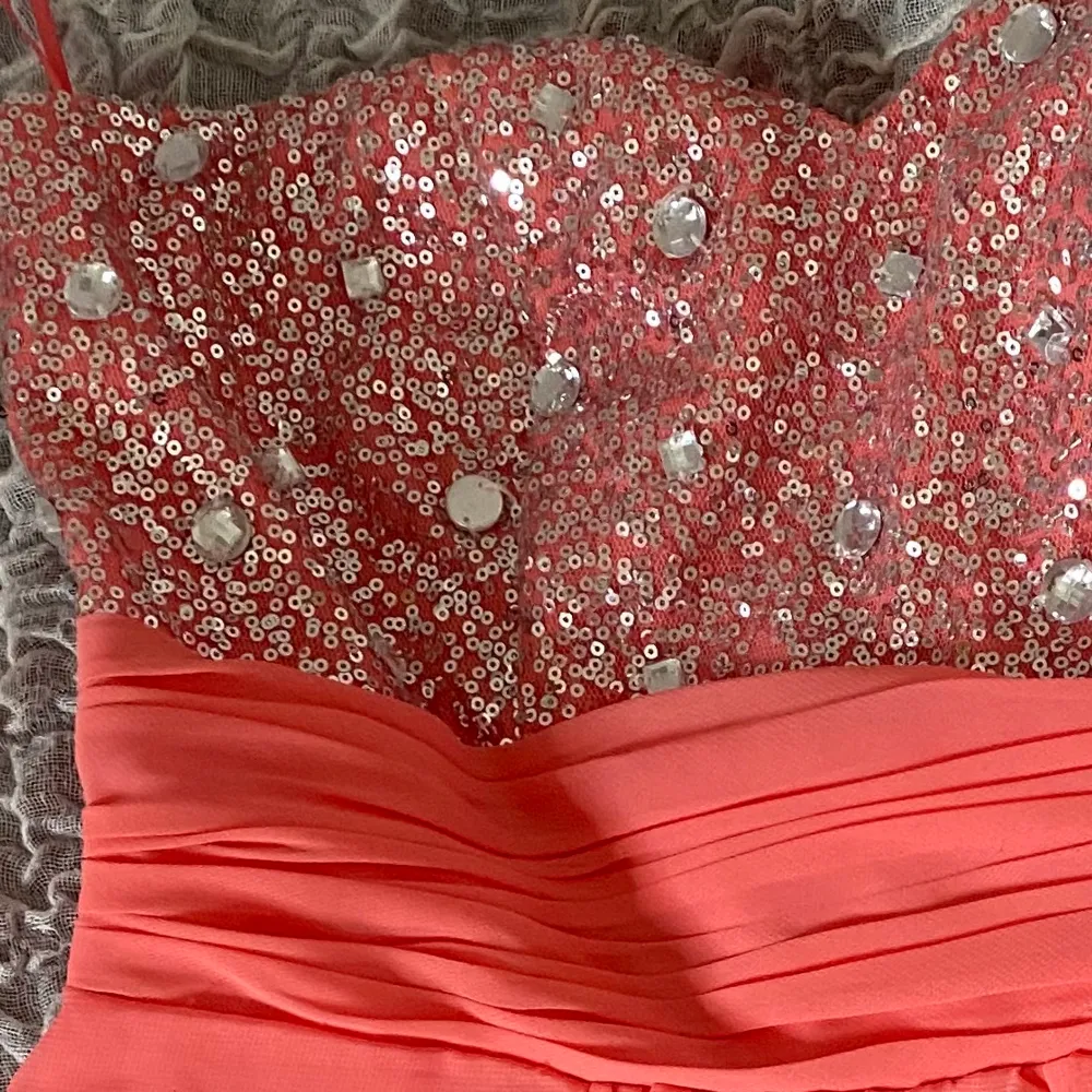 En jättefin rosa/corall glittrig balklänning som jag köpte på Sellpy. Säljer då den tyvärr var för liten i bysten på mig. En sten hänger löst på framsidan. Du står för frakten!!. Klänningar.