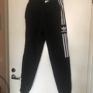 Adidas originals trackpants S - Jättefina adidas svarta originals byxor med vita ränder på sidorna. Går att använda både till träning, friluftsliv och till vardags. Har fickor med dragkedja. Mycket gott skick! Storlek: s
