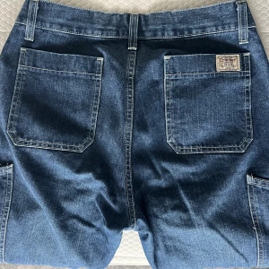 Cargo Jeans!!! - Supersnygga och trendiga cargo-jeans!! Stora och baggy på mig som är strl S (vilket är Supersnyggt) . Skulle säga att det är typ strl M W: 32 L: 32