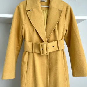 Gul kappa - Gul kappa från GinaTricots premium-colletion. Använd fåtal gånger så fortfarande i mycket bra skick! Så snygg nu till våren 💛