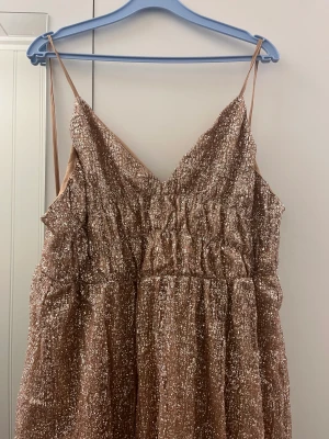 Balklänning  - Balklänning i storlek XL men passar som en M. Aldrig använd då den är för lång och för stor för mig!  Kan skickas! Är champanefärgad med glitter 🥰