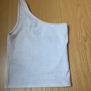 Vitt linne  - Vit linne med halv ärm. Det är ribbat. 