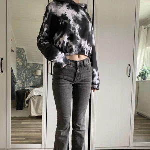 Fläckig luvtröja  - En vit-svart-grå luvtröja som har svart/gråa fläckar 