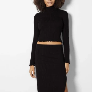 Set - Svart stickat set från Bershka. Polotröjan är lite cropad och sedan har kjolen en slits baktill. Använt endast en gång därav att jag säljer det! Storlek M❤️ om fler bilder önskas så är det bara att skriva. 250kr för båda delar!