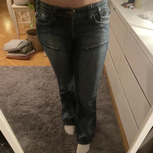 Lågmidjade bootcut jeans  - Jättefina lågmidjade bootcut jeans med unika och coola detaljer. Storlek M. Köpte begagnade men är i bra skick! 